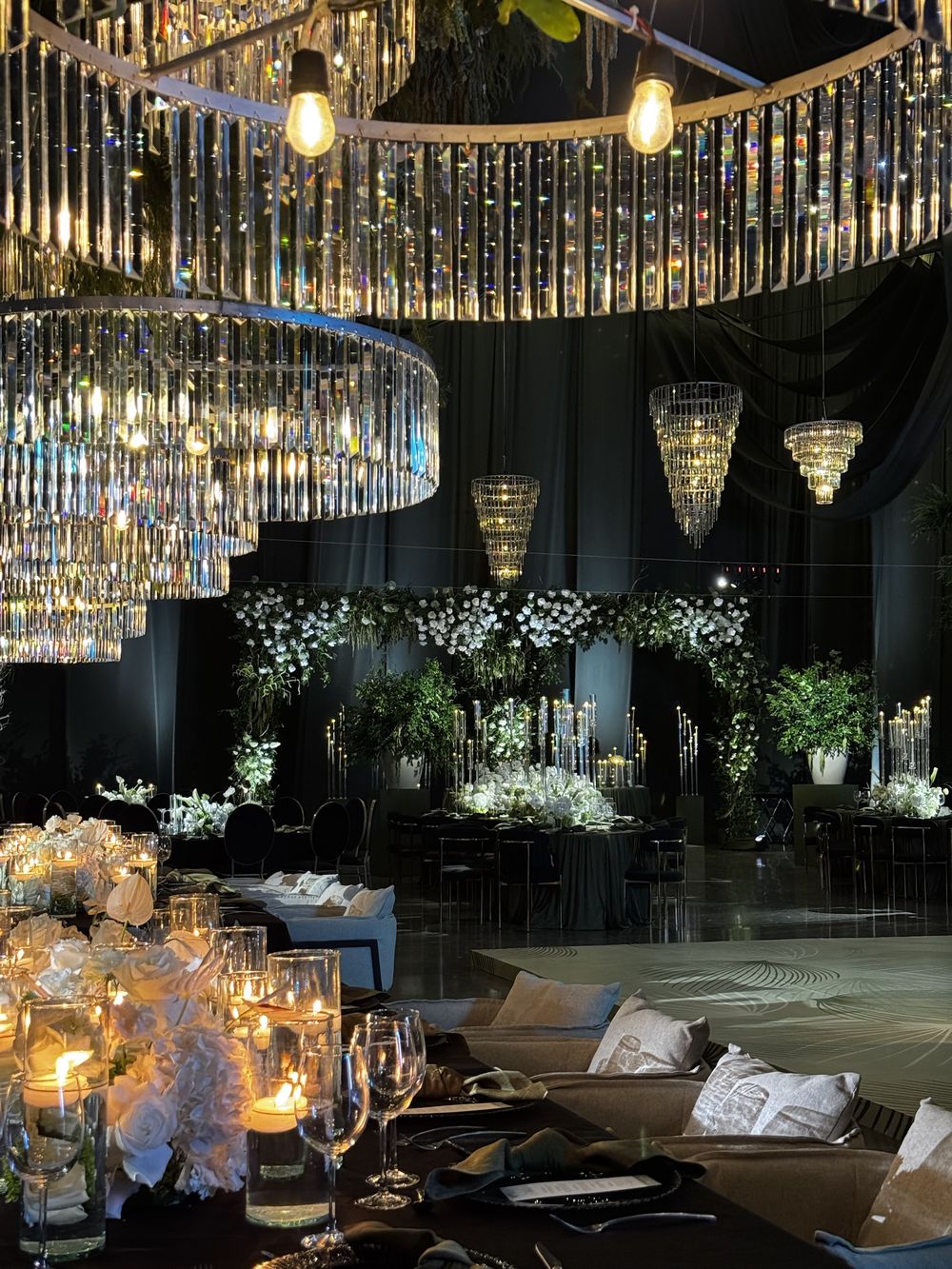 Salón con candelabros de cristal, back floral y mesas iluminadas