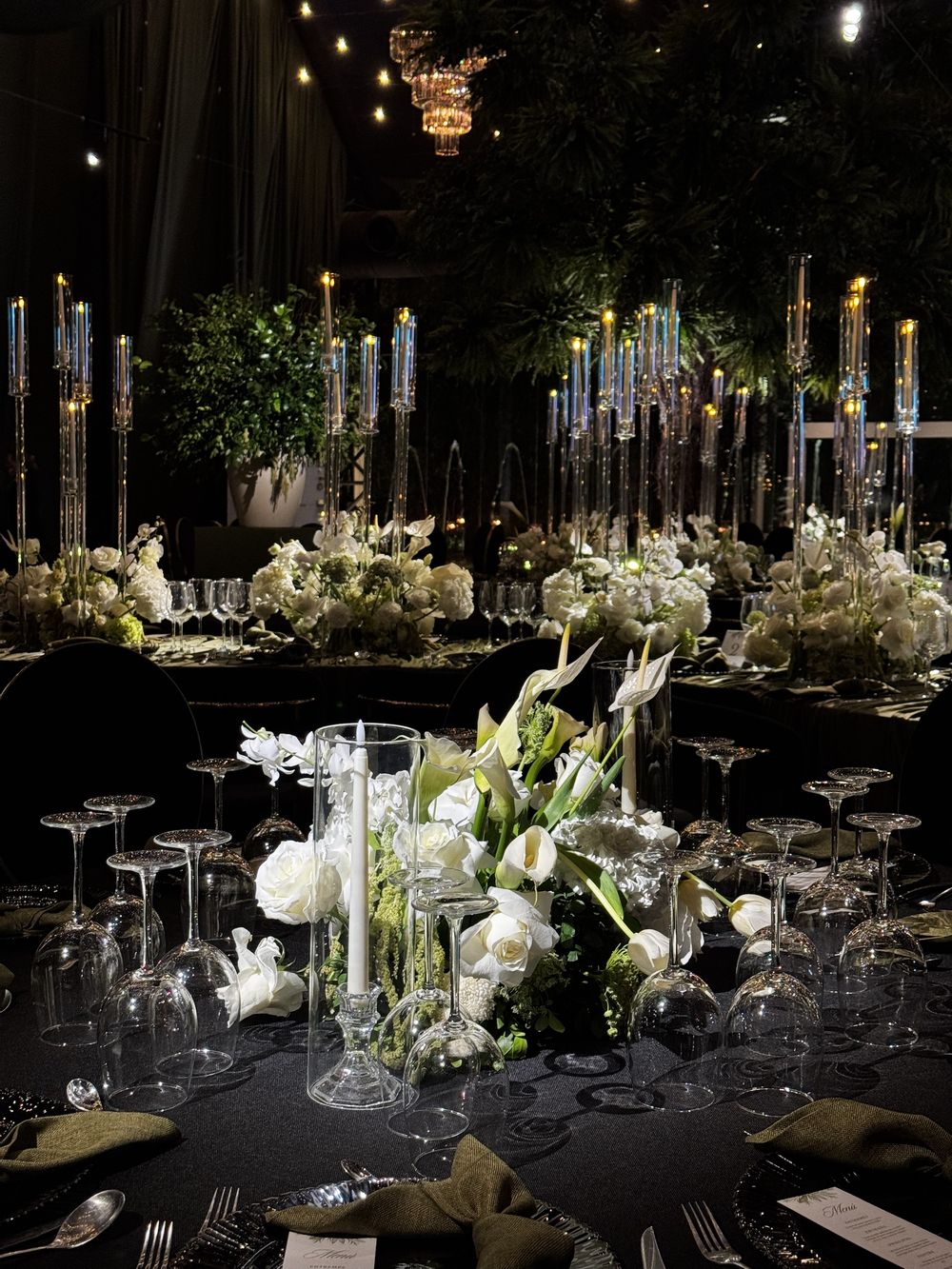 Centro de mesa de rosas y alcatraces blancos realzado con pin spot